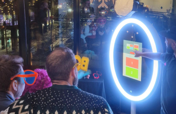 group of people wearing props taking a picture on a magic mirror photo booth